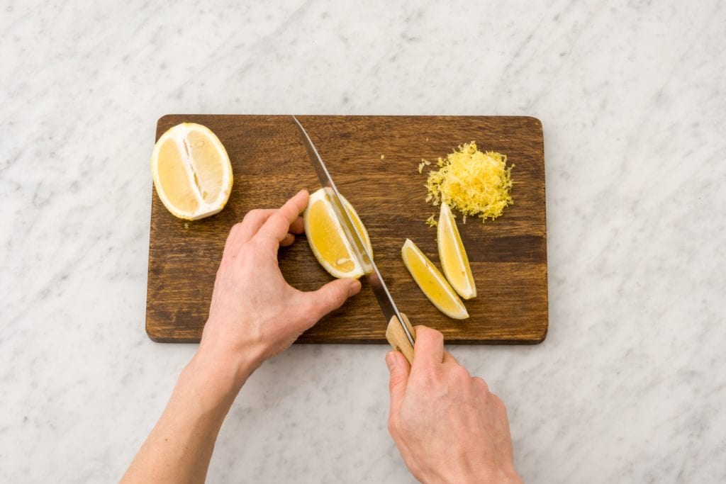Person slicing lemons on cutting board